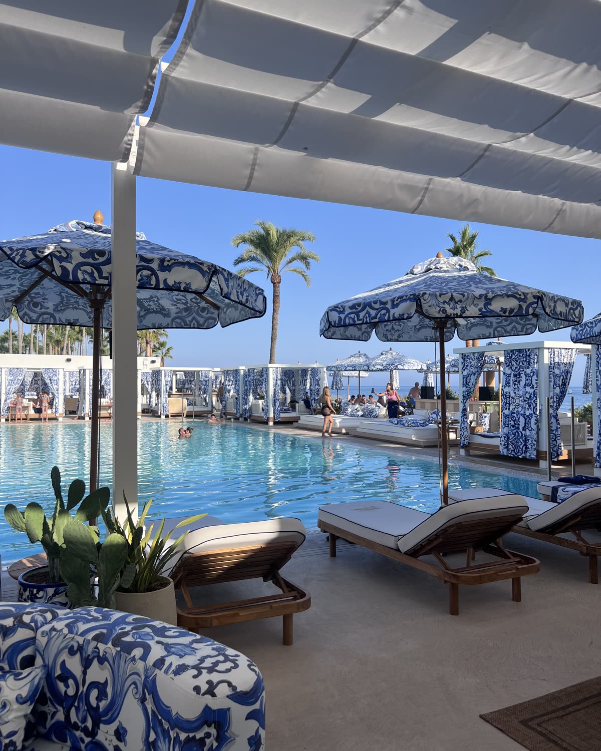 Beach club mediterráneo con sombrillas de cerámica azul