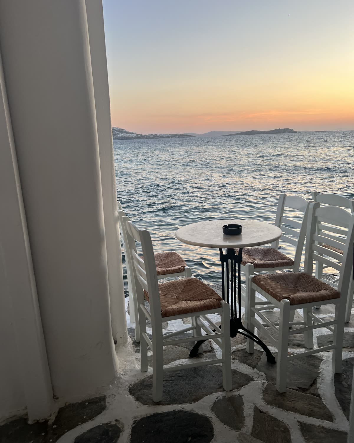 Mesa junto al agua al atardecer en las Cícladas